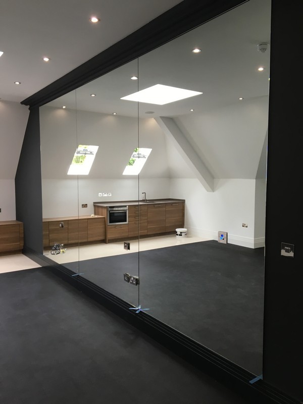 Frameless glass partition in loft conversion by Abbey Wood glaziers