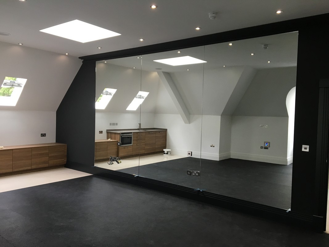 Frameless glass wall dividing loft conversion in Abbey Wood